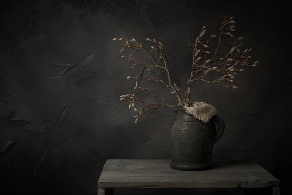 Stilleven met magnolia takken in knop – stenen kruik en linnen doek