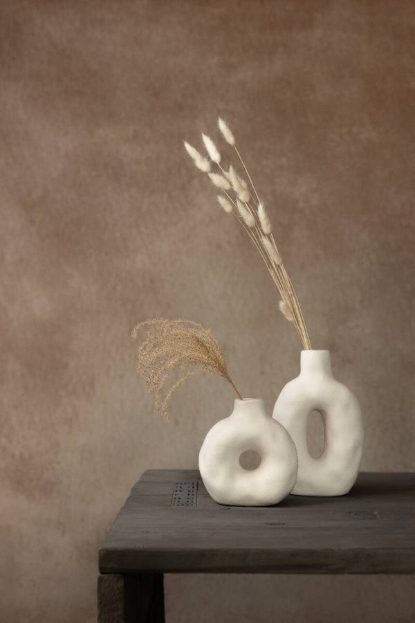 Stilleven met droogbloemen in witte organische donut vazen