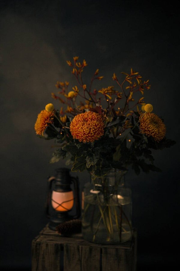 Stilleven van een herfstboeket en lantaarn – donker bloemen schilderij landelijke sfeer