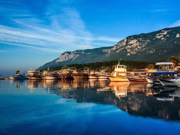 Tramonto ad Akyaka con barche ormeggiate nella baia sul Mar Egeo