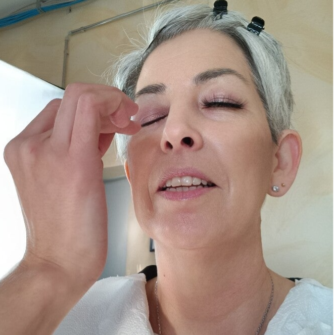 grauhaarige Frau wird geschminkt