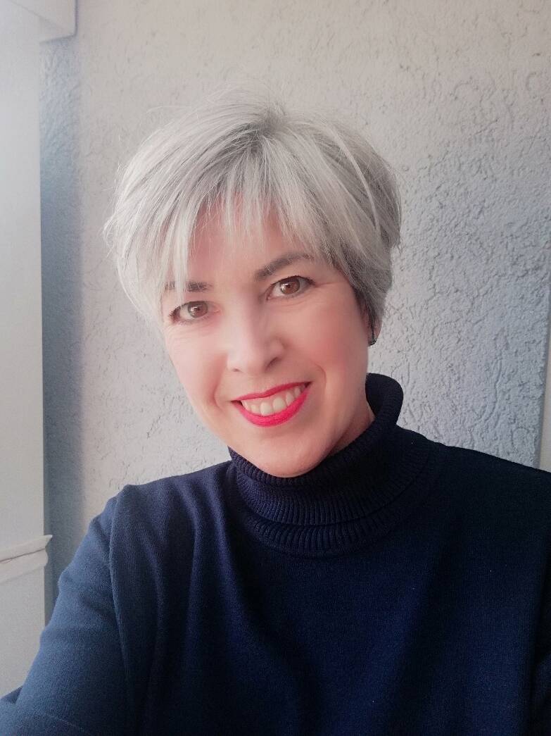 Grauhaarige Frau in dunkelblauem Rollkragenpullover 