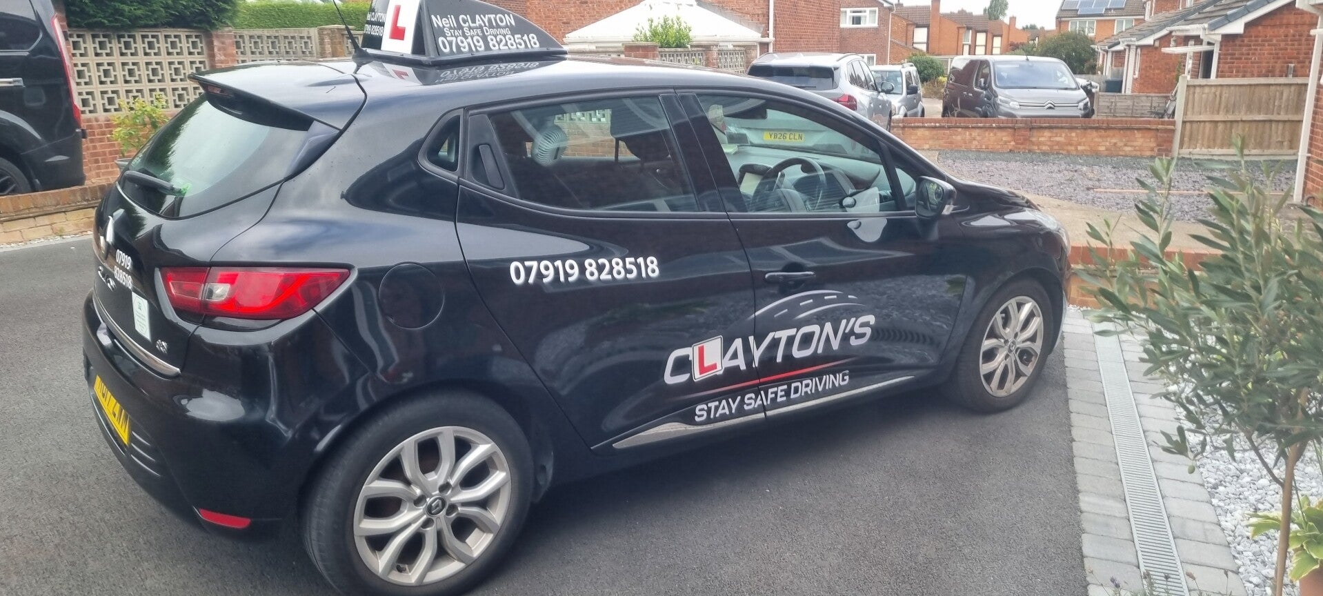 Clayton's Stay Safe driving school car parked on a quiet street.