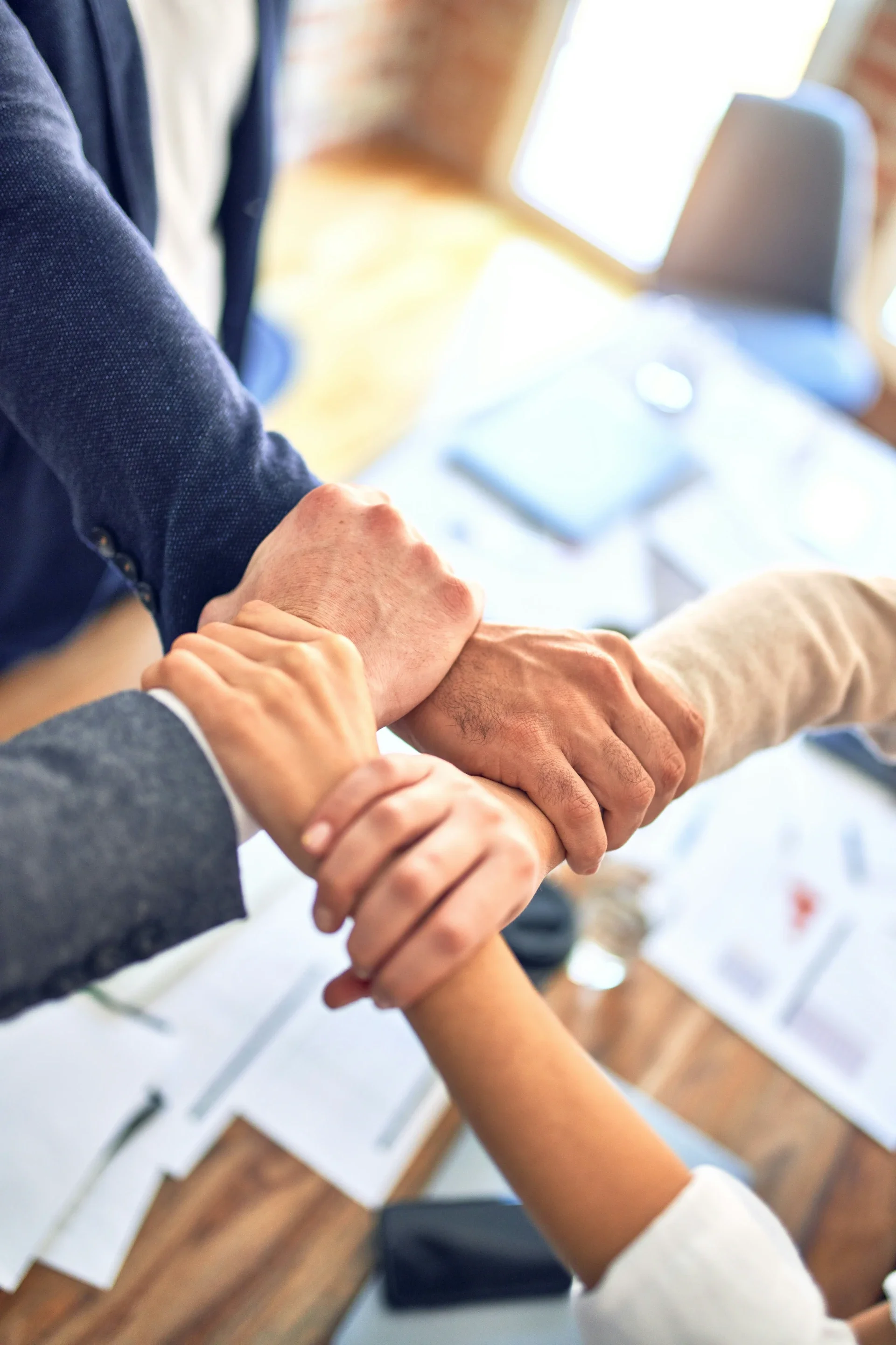 Business team holding hands together showing teamwork