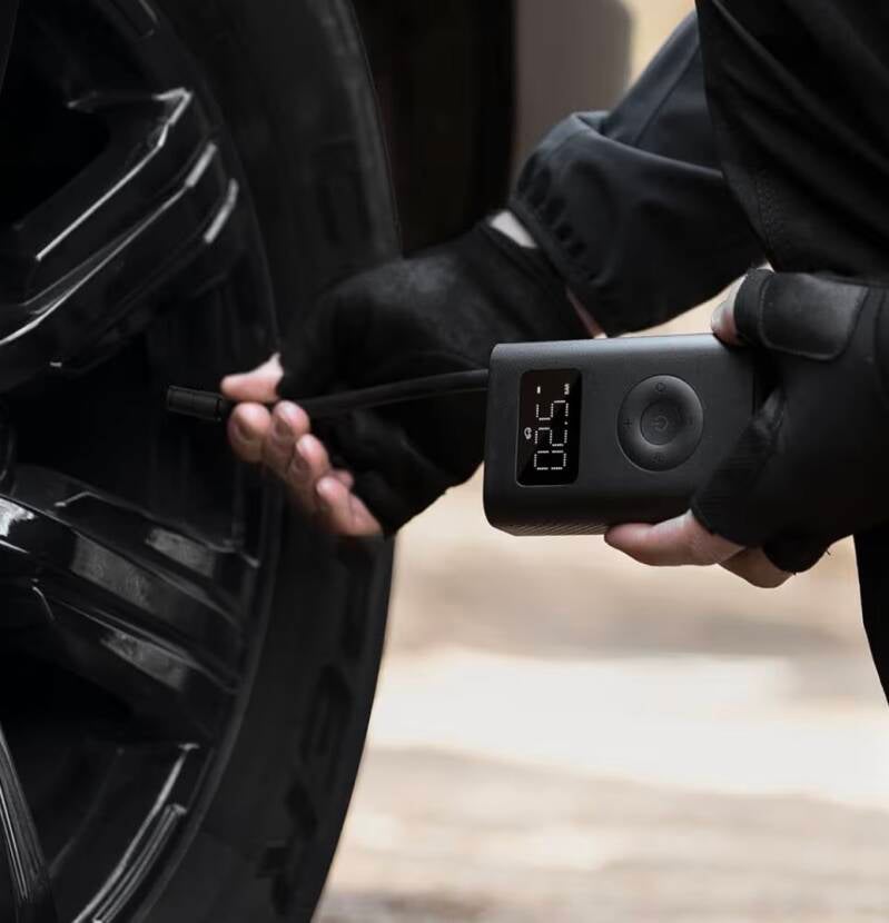 Inflador portátil Xiaomi inflando rueda de coche con ajuste automático de presión