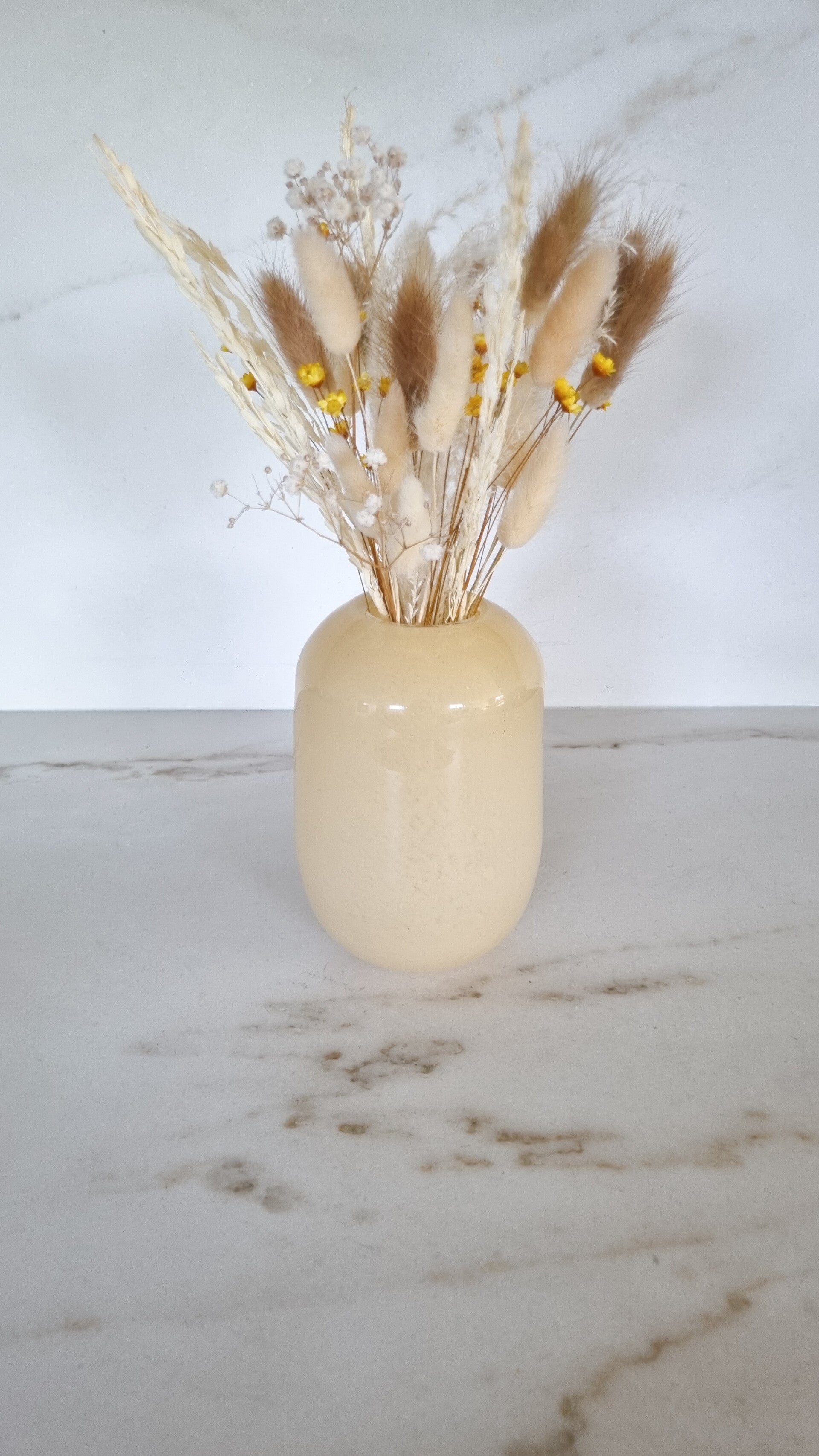 Botergele vaas met droogbloemen