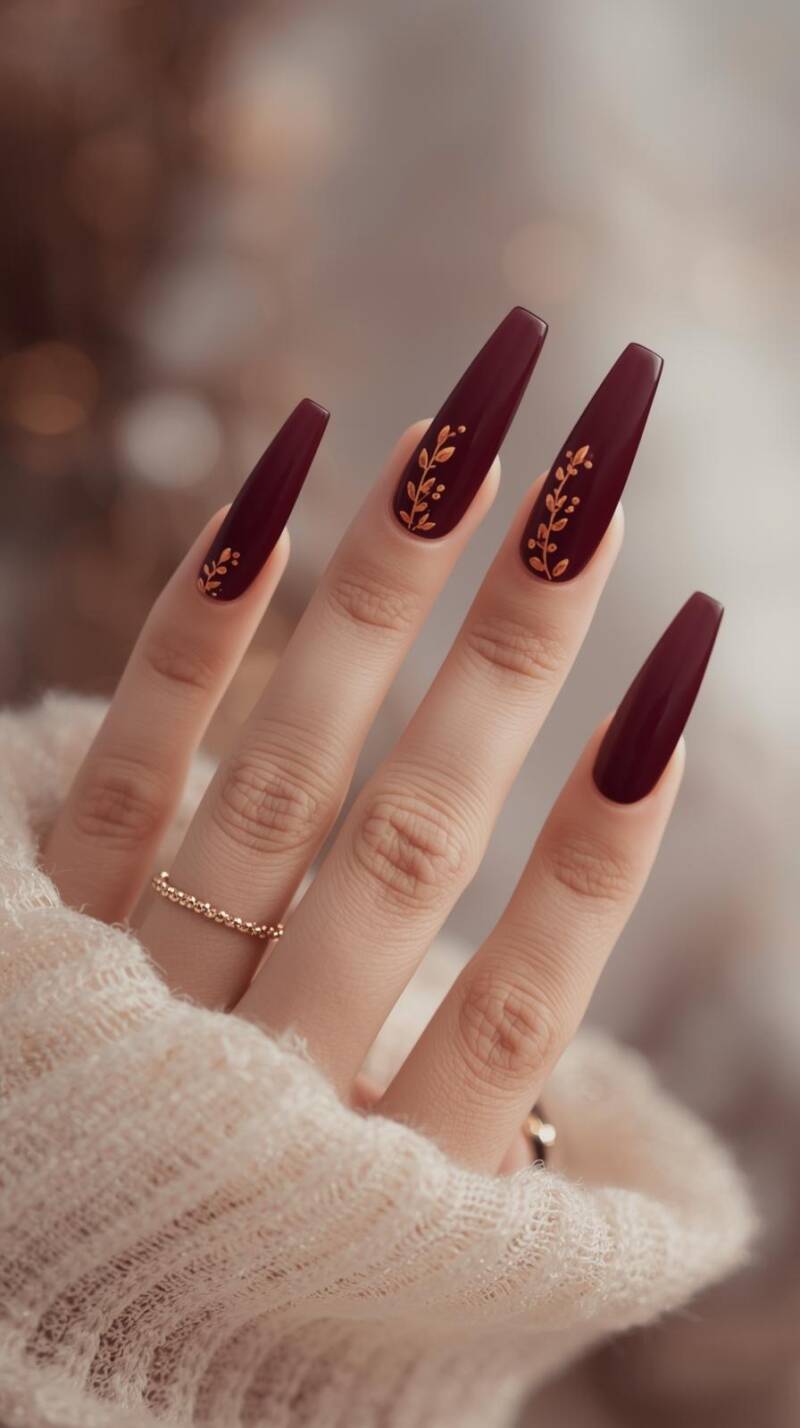 _a-close-up-of-a-female-hand-with-coffin-nails-painted-in-deep-burgundy-accent-nails-feature-cascading-tiny-golden-and-orange-leaves-as-if-falling-down-the-nail-t-1-standard-zrhuq7.jpg