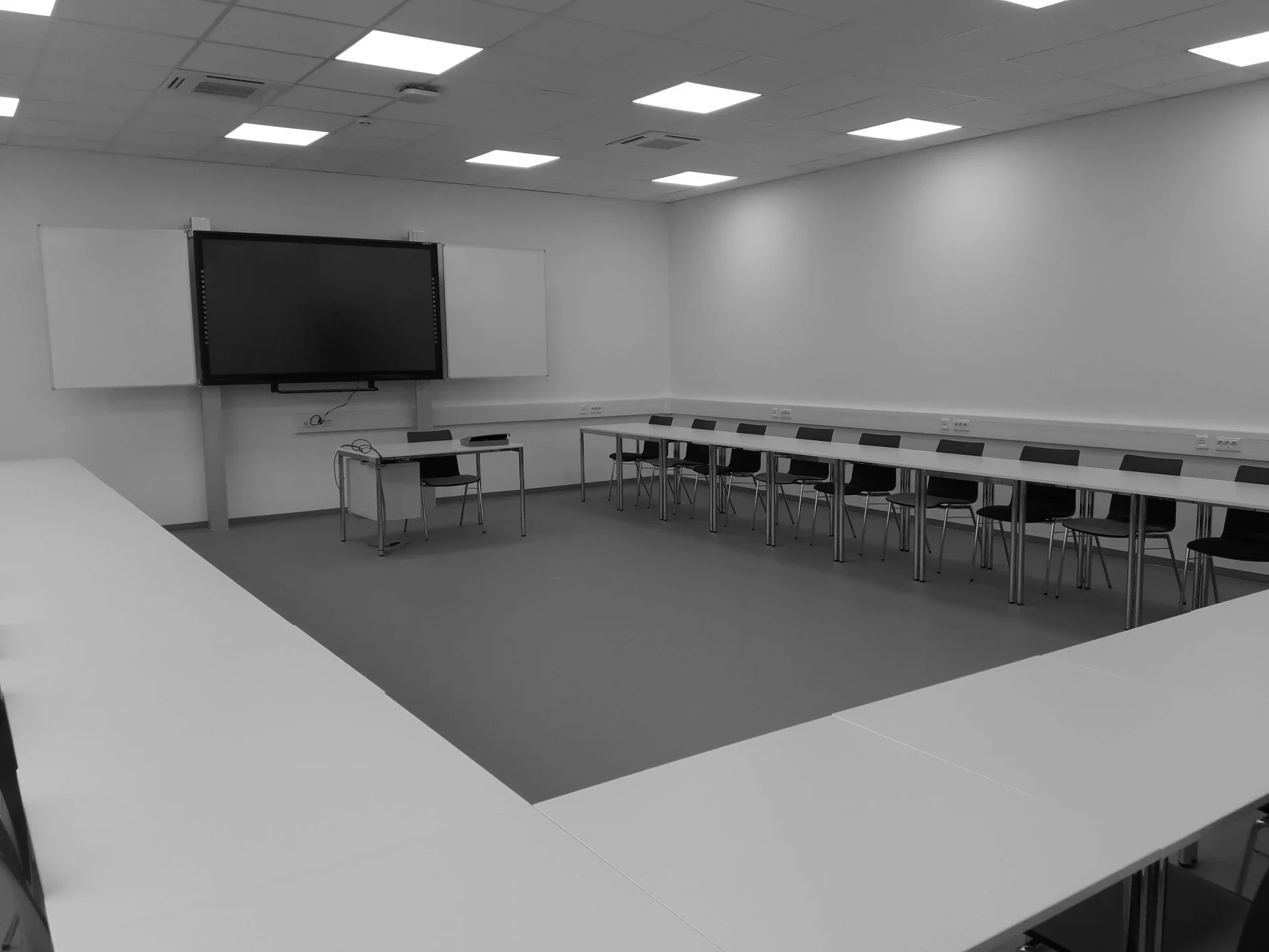 Moderner Seminarraum mit gewerkeübergreifender Gebäudeautomation für Beleuchtung, Beschattung und Schnittstelle zur Medientechnik.