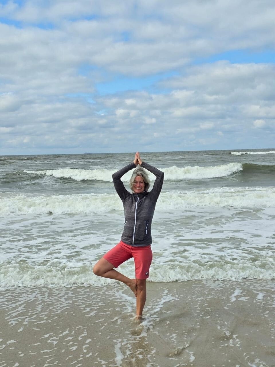 Yogalehrerin Sandra Birt in der Baumhaltung in der Brandung