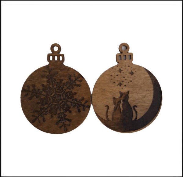 Lot de 2 boules de Noël en bois gravées l'une d'un couple de chats et l'autre d'un flocon de neige.