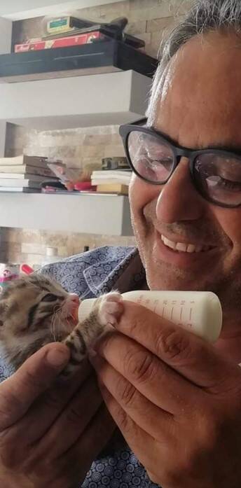 Mehmet füttert ein Kätzchen mit der Flasche