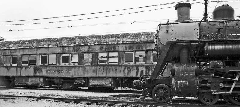 "Times Square" Pullman car on left, Norfolk and Western steam passenger locomotive 578 on right, without its headlight.
