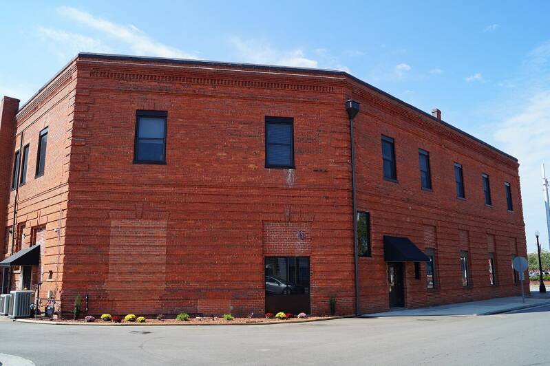 A large red brick building with several windows.