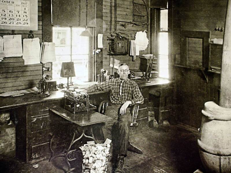 a clerk sits at a desk with a typewriter