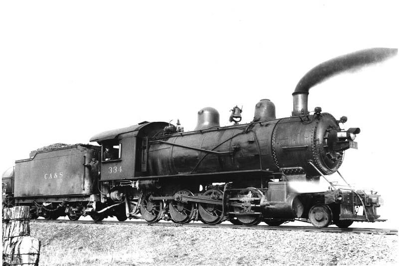 a 2-8-0 steam locomotive and tender running in reverse.