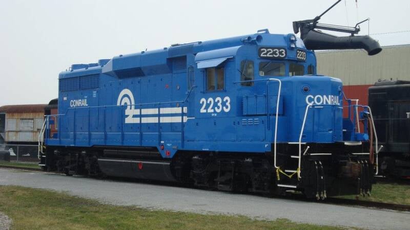 A blue diesel-electric locomotive with white text and logo