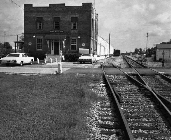 a 2-story building next to a railroad track