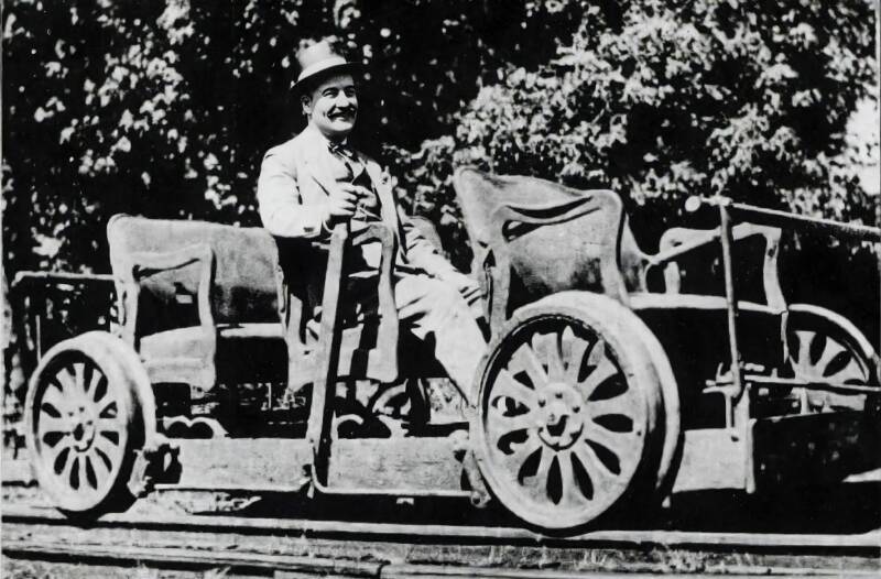 A man sitting on a small rail vehicle.