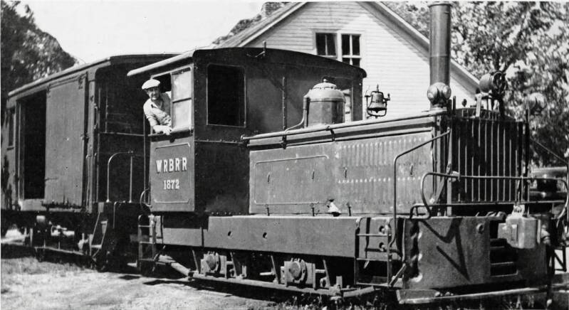 A man operating a small diesel-electric locomotive.