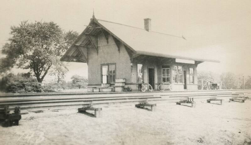 A small train station next to several train tracks.