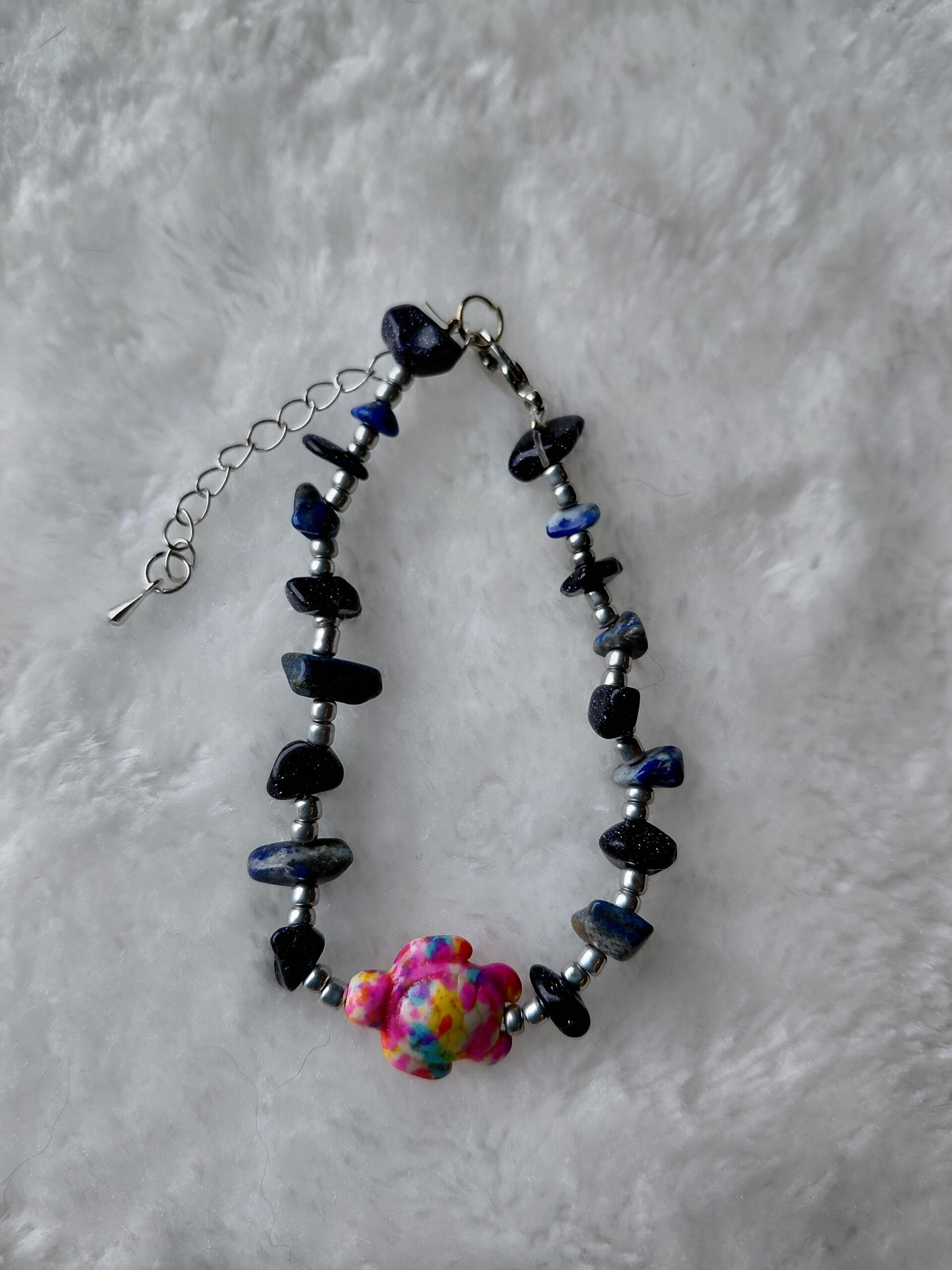 Handgemaakte armband met donkerblauwe 💙 natuursteen en kleurrijke blikvanger