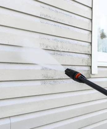 White vinly siding house being pressure washed