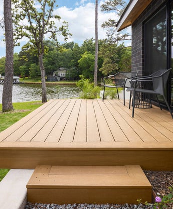 Freshly stained deck by JSP Painting at Lake of the Ozarks. Deck is painted a warm honey color and is on a loveley lot with gentle slope to the lake.