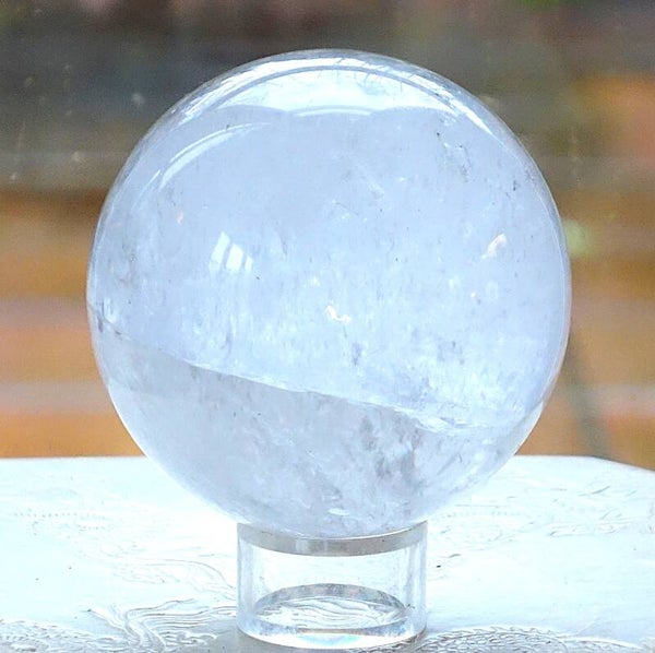 Mooie Bergkristalbol met kleine hematiet insluiting 10 cm