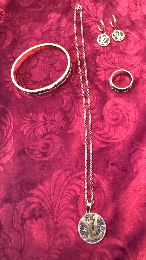Woman Gold Plated Necklace, Earrings, Ring and Bracelet with Beautiful LV Like Gold Design with Brown and Tan in background