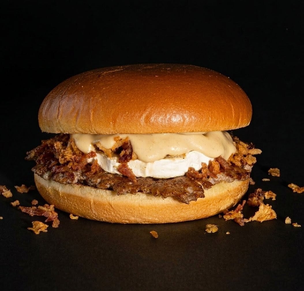 La YOKA'S BURGER perfecta combinación de carne smash, queso de cabra, bacon bits, cebolla crujiente & nuestra deliciosa salsa signature.  