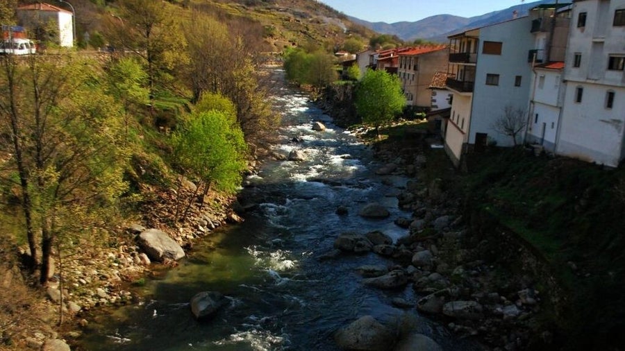 vista de una pueblo del valle del jerte por el que corre el cauce de un rio