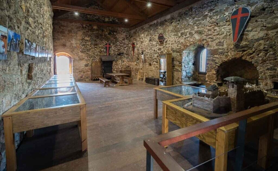 Sala de Interpretación del Castillo de Cornatel, adornada con escudos templarios y maqueta del castillo