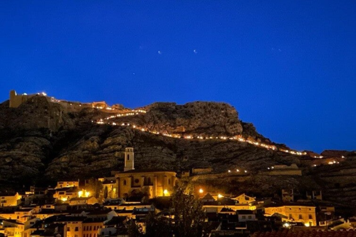 vista del castillo desde el pueblo castellote de noche en la subida con antorchas