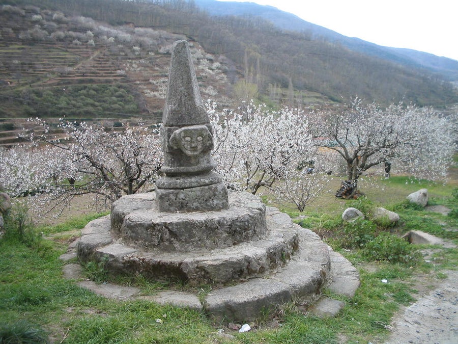 monolito de piedra en forma de piramide con una cara y puesto en una base circular con forma escalonada en el valle del jerte