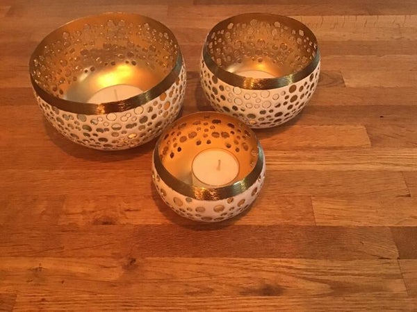 Witte th - lichtjes in metaal met gouden randen.