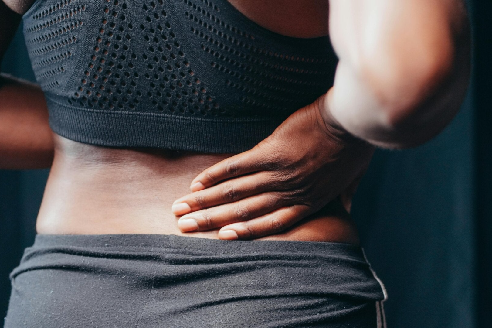 Post injury link. Picture of a person rubbing her lower back to indicate injury.