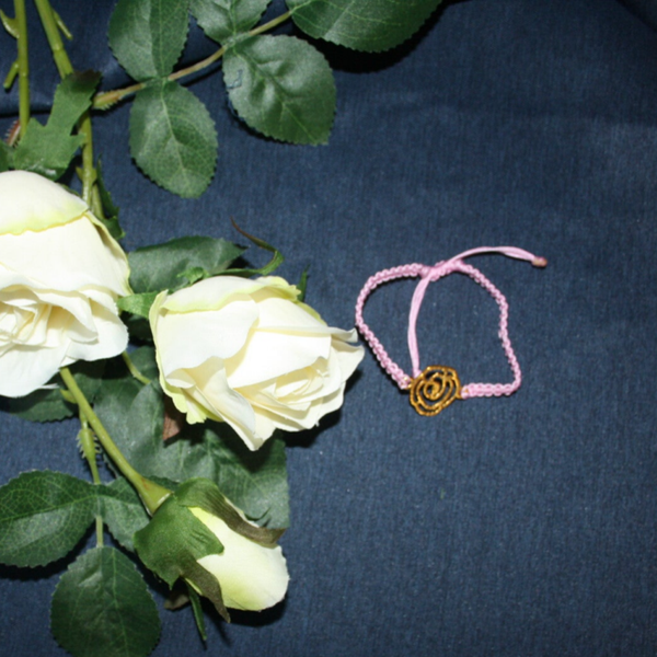 armbandje lichtroze met goudkleurige roosbedel