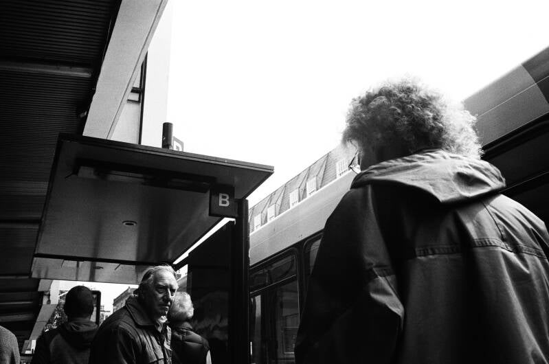 documentary photo from the streets of England, photo of bus stop that shows the viewer the tension of the streets,