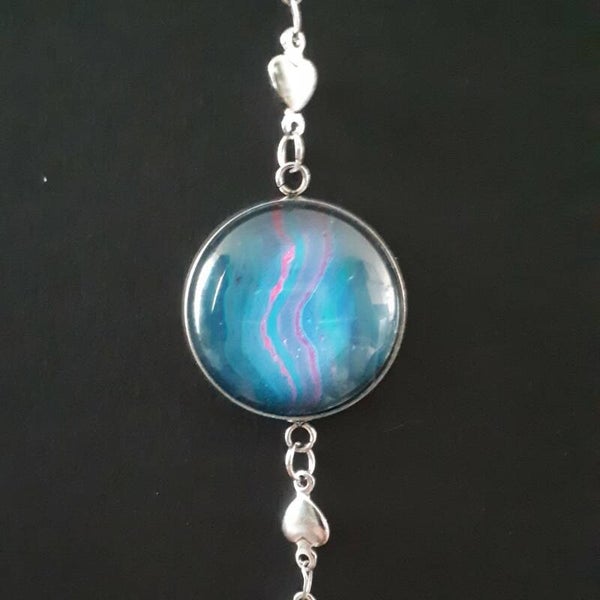 Adjustable silver-coloured bracelet with heart charms and a unique pink/purple accented stone Product # ArmSCSPHcab1