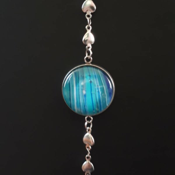 Adjustable silver-coloured bracelet with heart charms and a unique deep sea-coloured stone. Product # ArmSCSWWHcab1