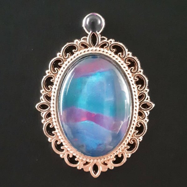 Unique pink/purple accented stone in intricate amulet-style oval necklace hanger Product # RGOMPTcab2