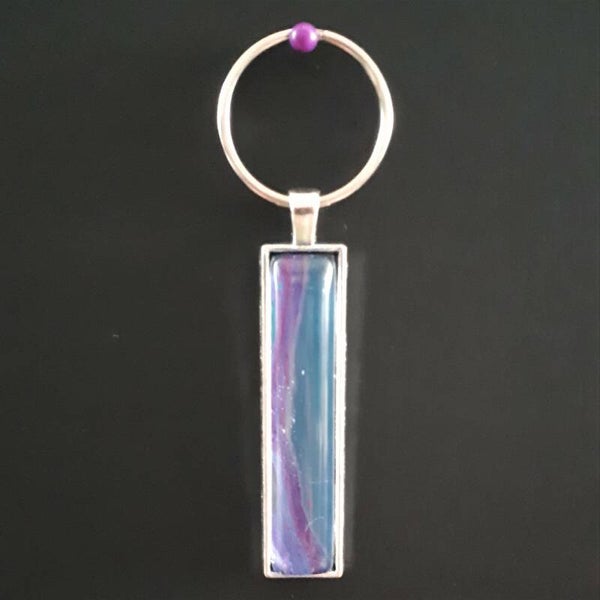 Silver-coloured keychain hanger with unique pink/purple accented stone Product # keySRLPcab2