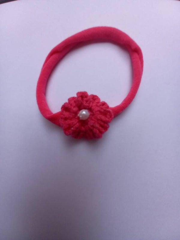 Fuschia kleur nylon haarbandje met een fuschia kleur bloemetje