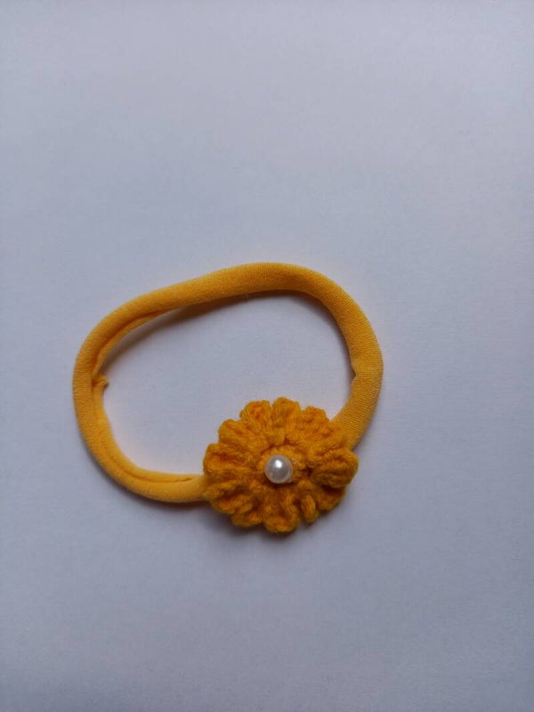Oker geel nylon haarbandje met een oker geel bloemetje
