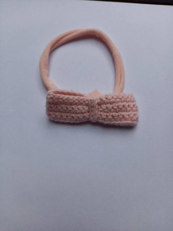 Een roze nylon haarbandje met een roze strik