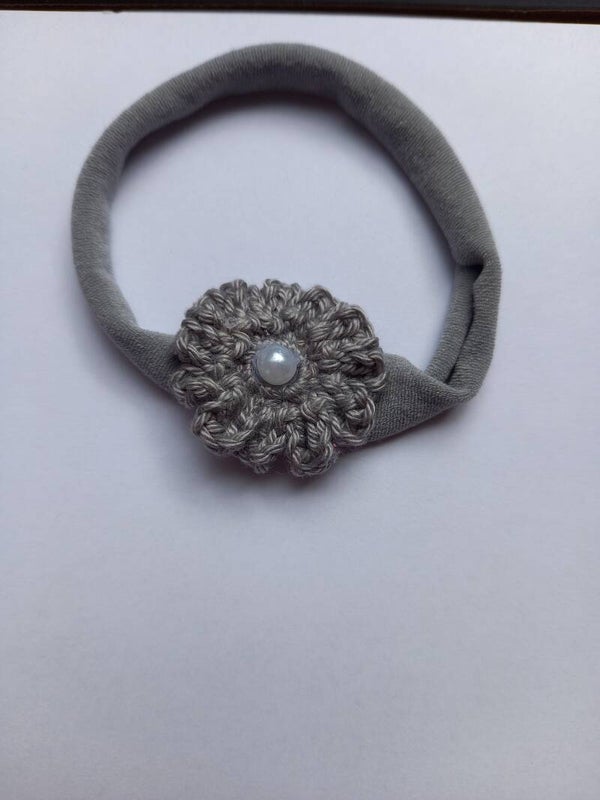 Een grijs kleur nylon haarbandje met een grijs bloemetje