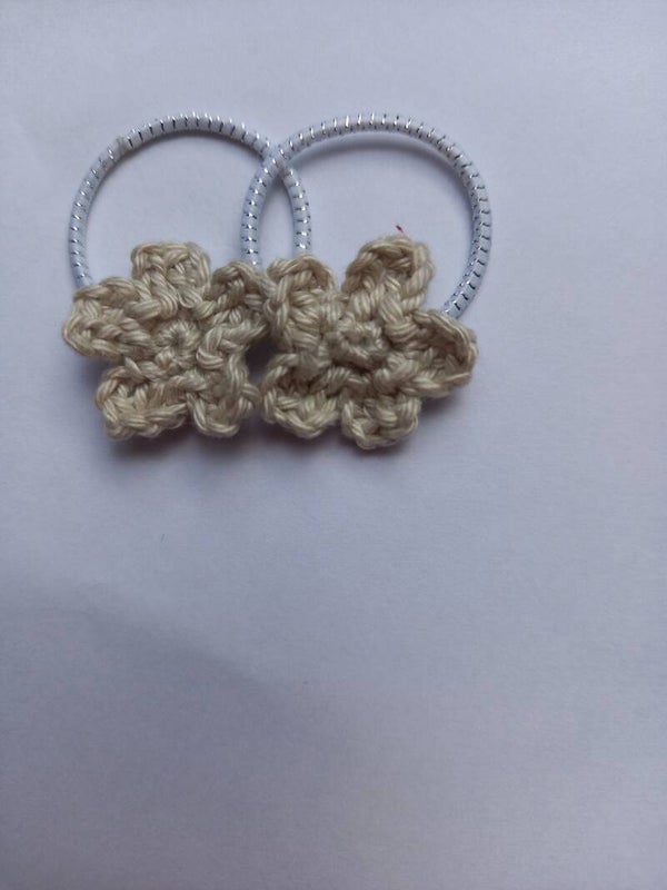 Witte stiekjes met een zandkleur bloemetje