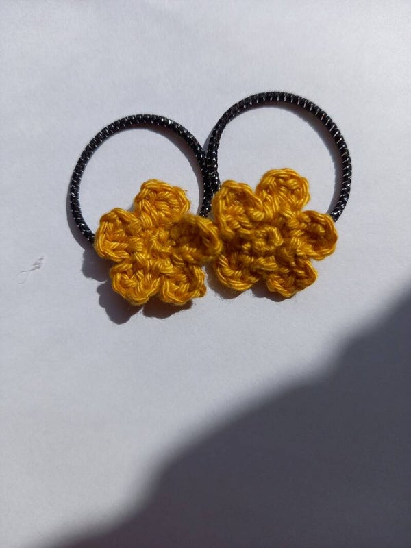 Zwarte stiekjes met een oker geel bloemetje