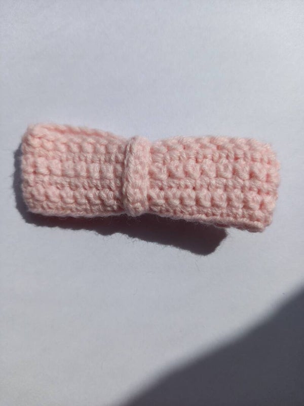 Een roze haar schuifje met een roze strik