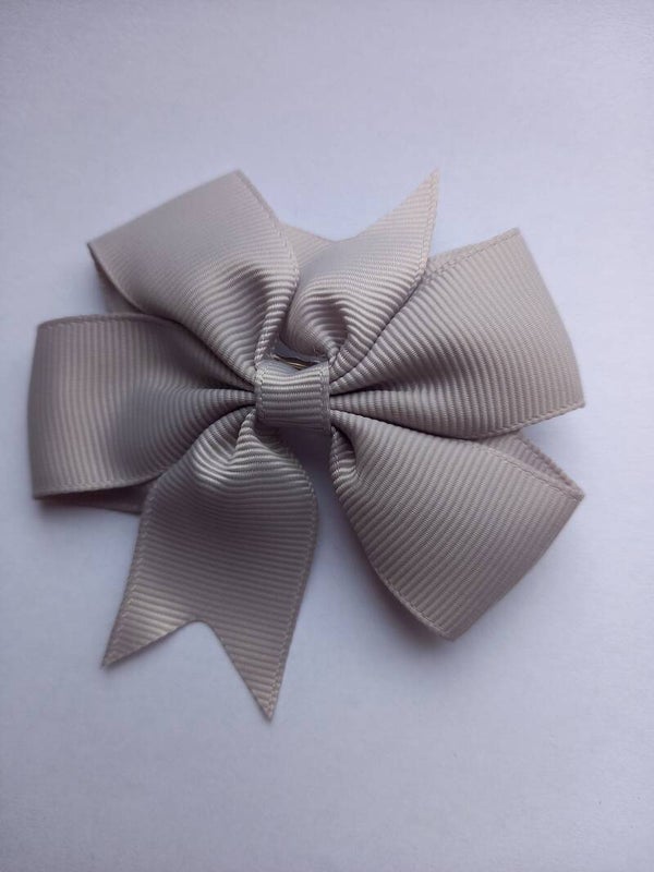 Een grijze kleur haarschuifje met strik